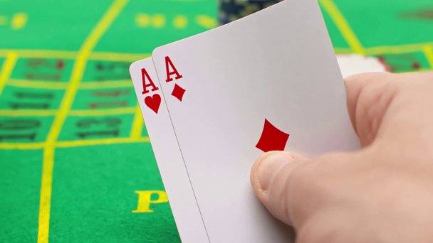 Nahaufnahme eines Mannes, der Spielkarten hält und Pokerchips zieht - Filmmaterial, Video
