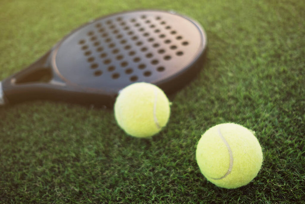 Paddle tennis racket and ball on turf still life, focus on ball - Foto, imagen