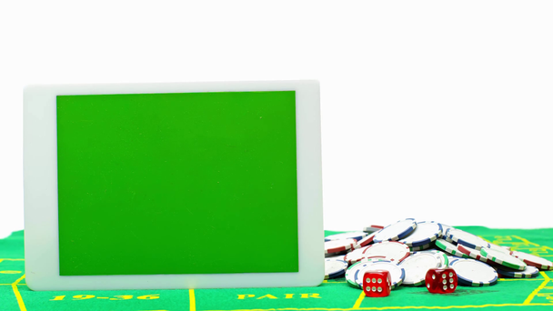 Poker çiplerinin yanında yeşil ekranlı dijital tablet ve beyaz üzerine izole edilmiş zar - Video, Çekim