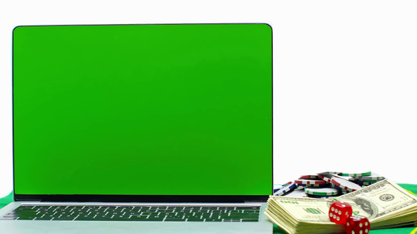 laptop with green screen near poker chips, money and dice isolated on white - Footage, Video