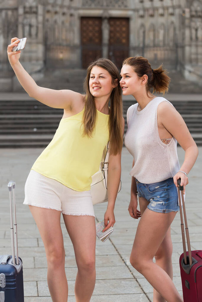 positive belgian tourists  walking in the town and taking selfie on phone - Foto, Bild