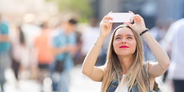 Jolie adolescente prenant un selfie avec son téléphone portable en plein air dans la ville
 - Photo, image
