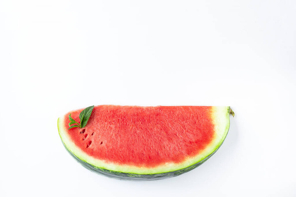 Sliced of fresh red ripe watermelon with green leaves of mint on white background - Фото, изображение
