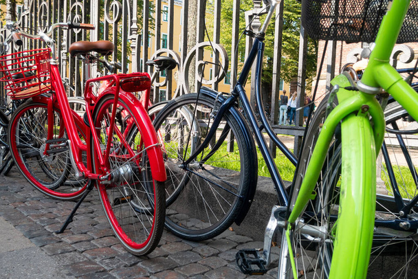 Colourful bicycles parked by railings in Copenhagen, Denmark - Fotografie, Obrázek