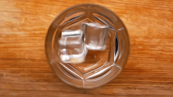 vue du dessus des glaçons tombant dans le verre vide sur une table en bois, au ralenti
 - Séquence, vidéo