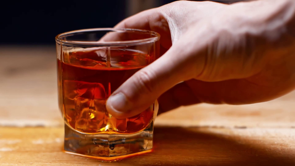 částečný pohled om taking glass of whiskey isolated on black, slow motion - Záběry, video