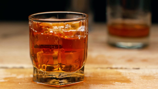 slow motion of ice cubes falling into glass of whiskey isolated on black - Footage, Video