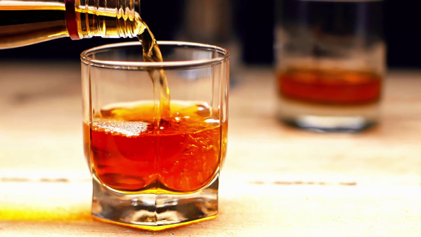 rallentatore di versamento del whisky dalla bottiglia al bicchiere isolato sul nero
 - Filmati, video