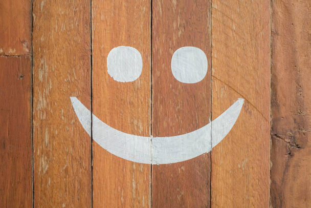 Smiley emoticon pintado sobre fundo de madeira
 - Foto, Imagem