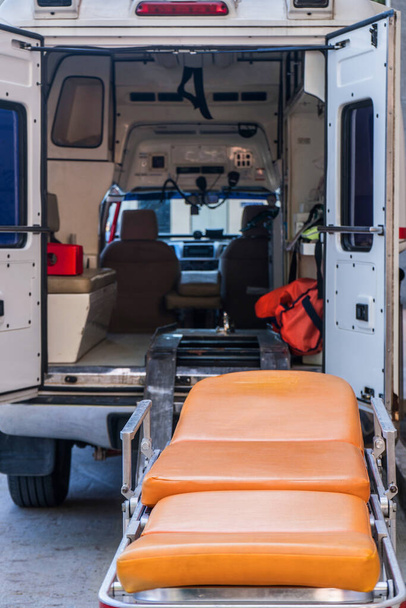 Pohotovostní nemocniční vozík s pozadím sanitky s otevřenými zadními dveřmi - Fotografie, Obrázek