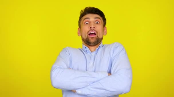 Bearded man turns to the camera and is shocked on a yellow background - Footage, Video