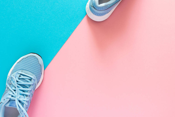 Blue sneakers isolated on pink and blue background, seasonal shoes for walking and sports, copy space, top view - Photo, Image