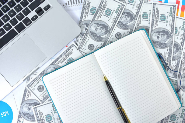 Geschäftskonzept. Laptop, Grafik und Banknote Dollar mit Notizbuch und Stift - Foto, Bild