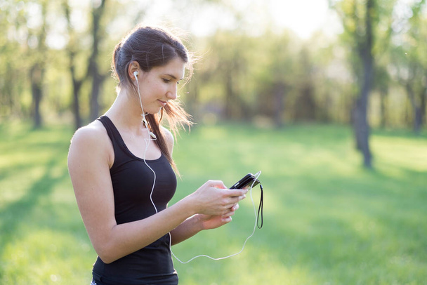 Sporty woman with smart phone - Photo, Image