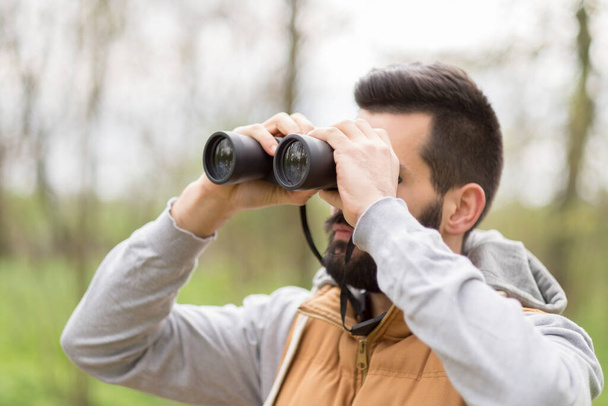 young man with binoculars in the park - Zdjęcie, obraz