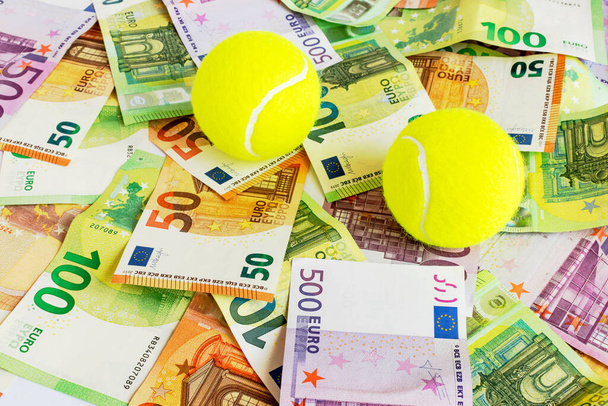 テニスボールと現金ユーロ紙幣。スポーツ投資、賞金および賭けの概念。ビジネステニスの背景. - 写真・画像