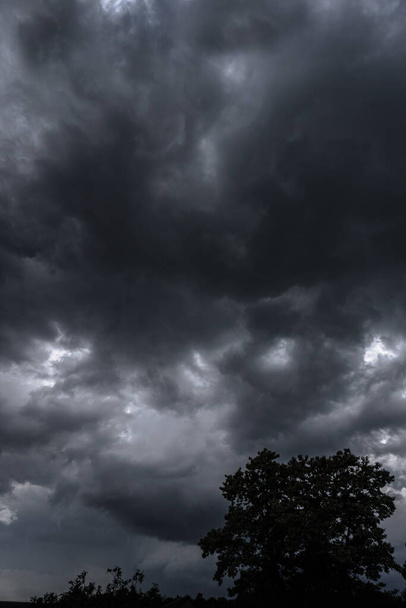 Vreselijke donderwolken van de zijkant van een vliegtuig. Grimmige epische wolken. Achtergrond afbeelding in een donkergrijze stijl. - Foto, afbeelding