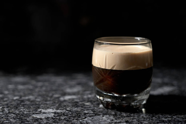 ijskoffie in glazen bodem met zwarte achtergrond - Foto, afbeelding