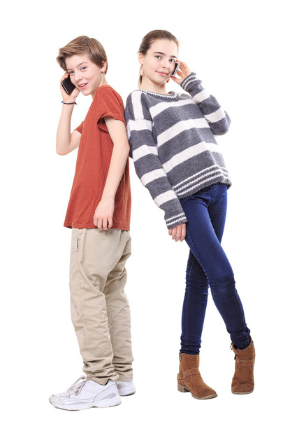 two smiling teenager, back on back with their mobile phones, iso - Fotoğraf, Görsel