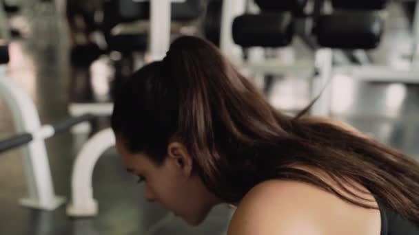 crane video shot of beautiful woman is pushing up inside the gym. She is strengthening arm muscles, side view. - Metraje, vídeo