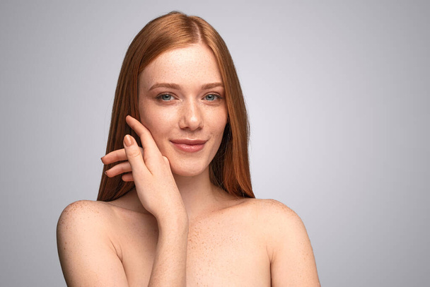 Young woman touching freckled skin - Photo, Image
