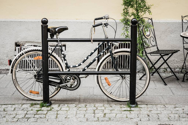 POZNAN, POLAND - May 30, 2014: Bicycle locked on a metal barrier in the city. - Zdjęcie, obraz