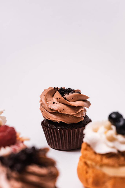 A selective focus of a chocolate cupcake on the table under the lights - perfect for food concepts - Photo, Image