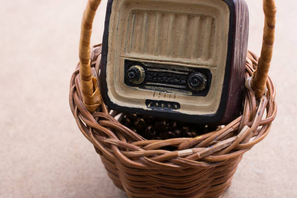 A closeup view of a small hand-made radio in a wooden basket - Zdjęcie, obraz