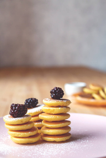 Stacks trendy tiny pancakes on pink plate. - Φωτογραφία, εικόνα