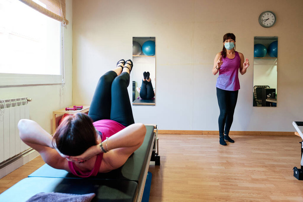 grupa dojrzałych kobiet robi ćwiczenia, Pilates i Joga z dystansu społecznego i maski twarzy - Zdjęcie, obraz