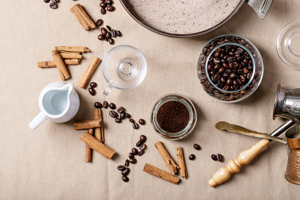 Fresh coffee beans in glass jar over textile cloth brown background. Top view, flat lay - Fotografie, Obrázek