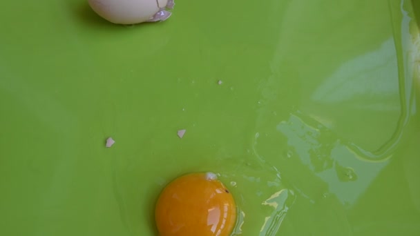 ραγισμένο αυγό κοτόπουλου σε πράσινο φόντο, κοντινή προβολή  - Πλάνα, βίντεο