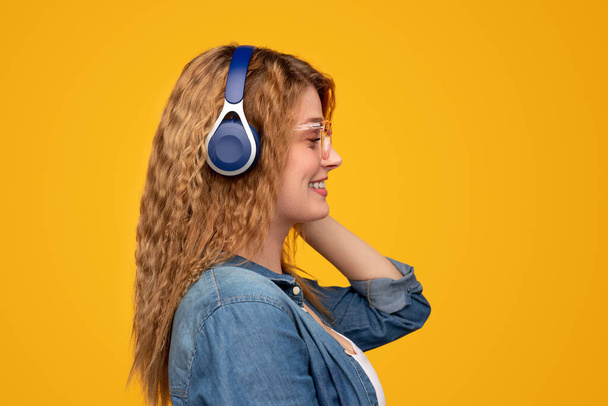Modern female smiling and listening to music - Foto, Bild