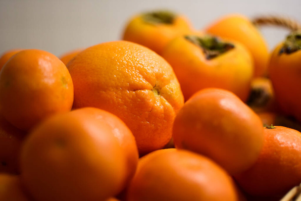 Orange fruits close-up. Oranges, tangerines and persimmons. - Photo, image