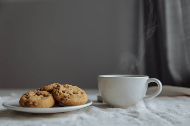 brown cookies on the white plate and coffee in white glass - Fotoğraf, Görsel