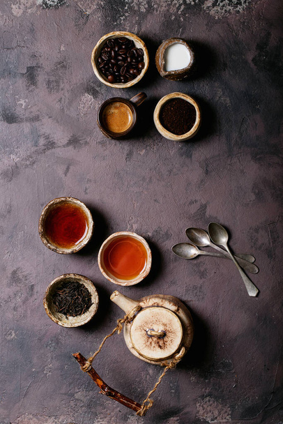 Black tea in a ceramic cup versus espresso coffee over a brown texture background. Top view. Copy Space - Fotoğraf, Görsel