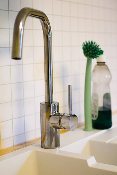 Kitchen faucet on a white wall background.  Close-up - Zdjęcie, obraz