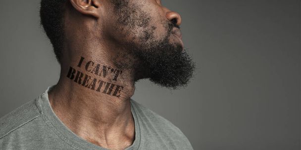Close up portrait of a black man tired of racial discrimination has tattooed slogan on his neck - Zdjęcie, obraz