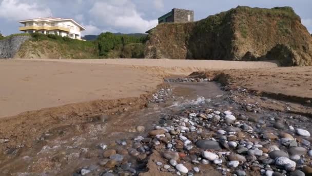 Água que desce ao mar através de um pequeno riacho formado na praia
 - Filmagem, Vídeo