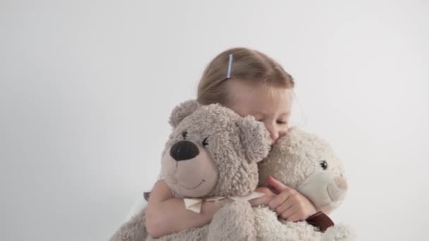 A beautiful little girl plays with teddy bears - Imágenes, Vídeo