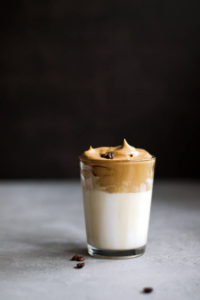 Dalgona Coffee in a transparent cup. South Korean drink with whipped instant coffee, sugar and milk. - Foto, immagini