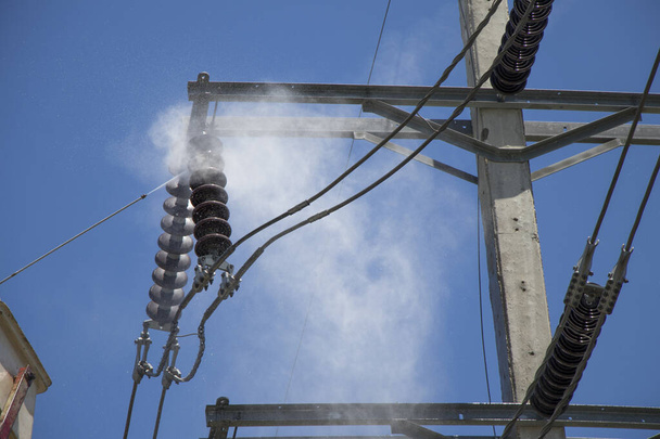 Electricity authority clean the ceramic insulator on the electric pole by high pressure washers. - Photo, Image