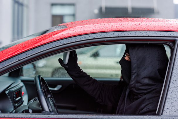 Boční pohled zloděje nastavení zrcadla při sezení v autě  - Fotografie, Obrázek