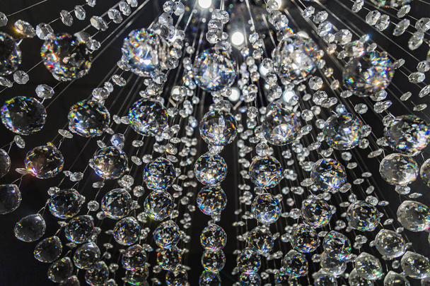 Pendentif lustre en cristal abstrait ou boules à facettes en cristal sur fond noir
 - Photo, image