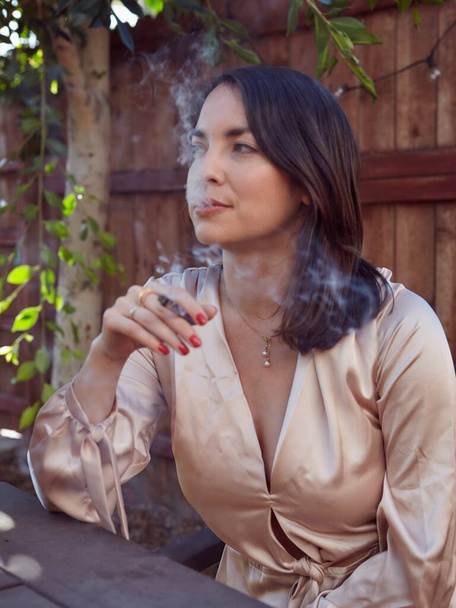 Stylish Woman Smoking a Joint Outside in her yard. - Photo, image