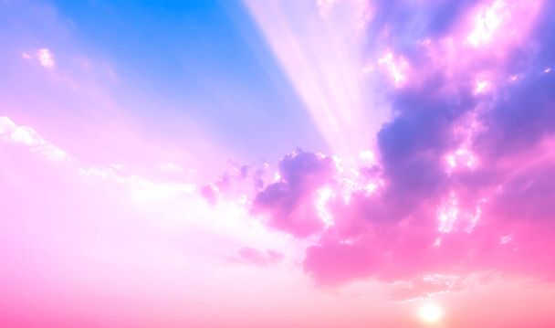 paars en roze kleur licht op schemering hemel met zonnestralen en wolken - Foto, afbeelding