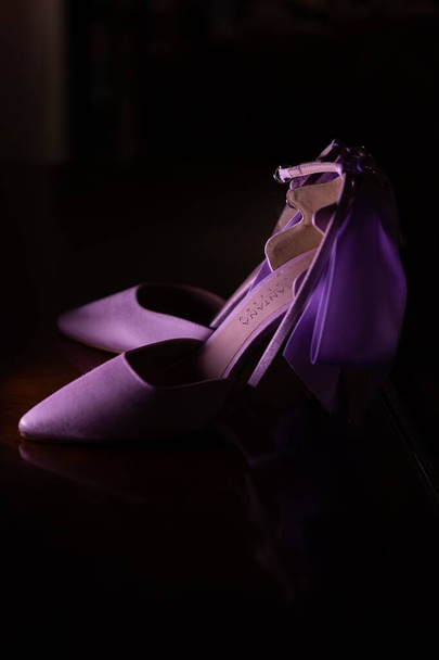 A closeup shot of beautiful and elegant purple heels isolated on a black background - Zdjęcie, obraz