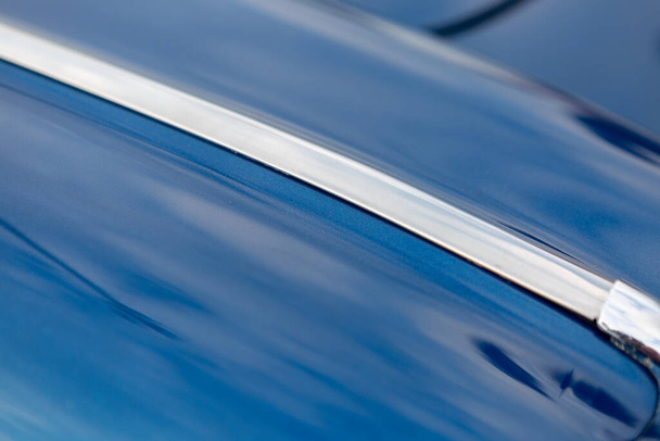 Fragment of a vintage car - blue body with chrome strip - Foto, Imagen