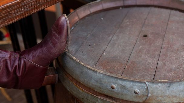 Bota de mujer roja descansa en el viejo barril de vino
 - Foto, imagen
