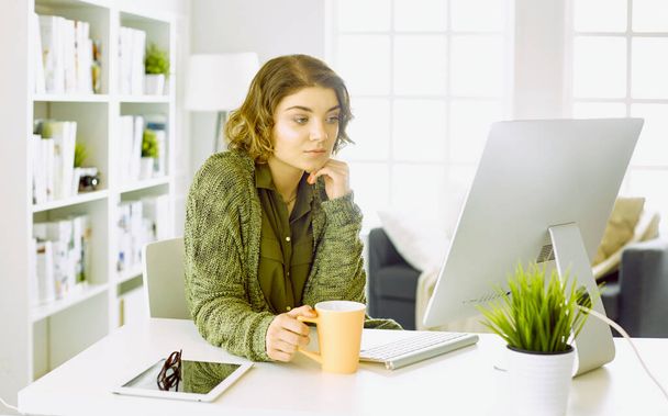 Giovane donna che lavora con tablet grafico in ufficio
 - Foto, immagini